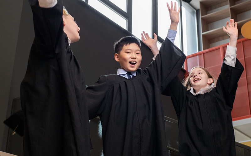 Children cheering and singing during a language immersion music activity.