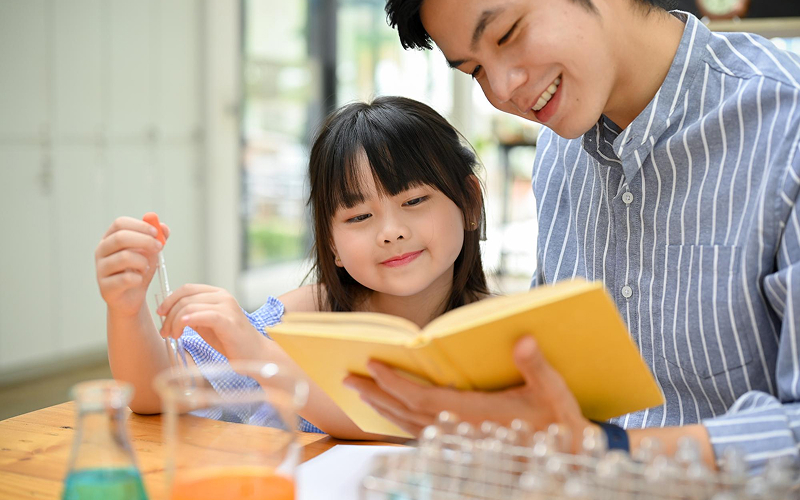 Parent using a storybook to explain Chinese language concepts.