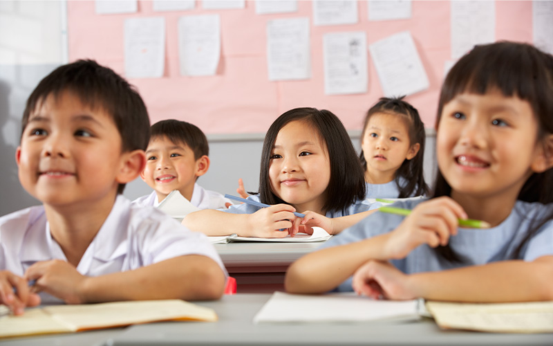 Children studying in classroom setting.
